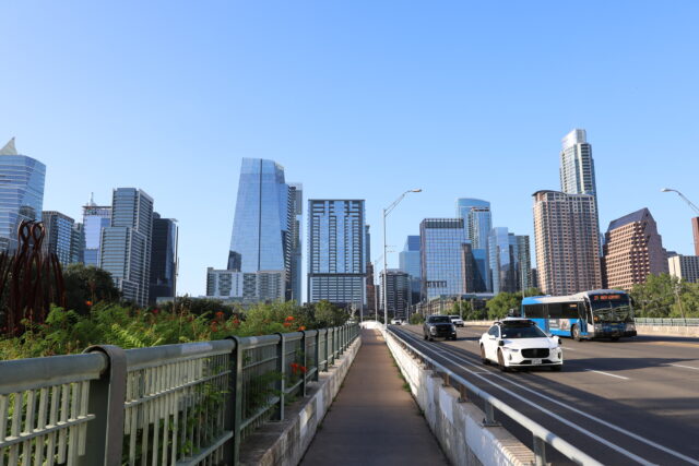 picture of austin downtown on 1st street featuring a city bus and robot car