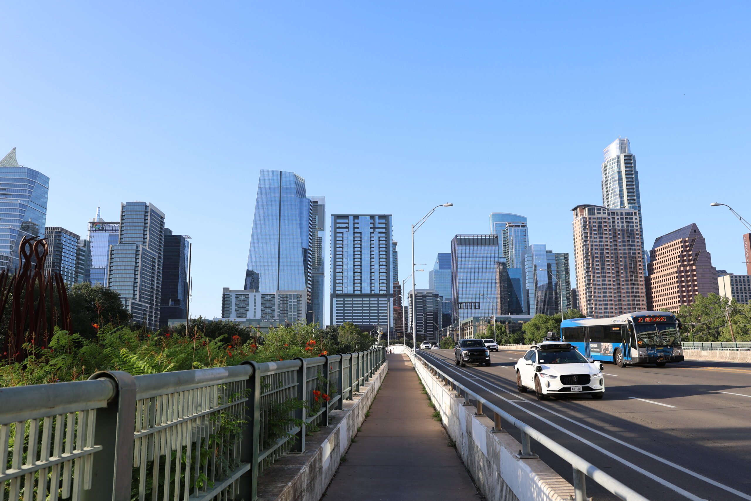 picture of austin downtown on 1st street featuring a city bus and robot car